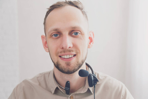 Young attractive friendly smiling man with headset for online communication as professional virtual client support or customer service or during online conference and chatting. - Fotoğraf, Görsel