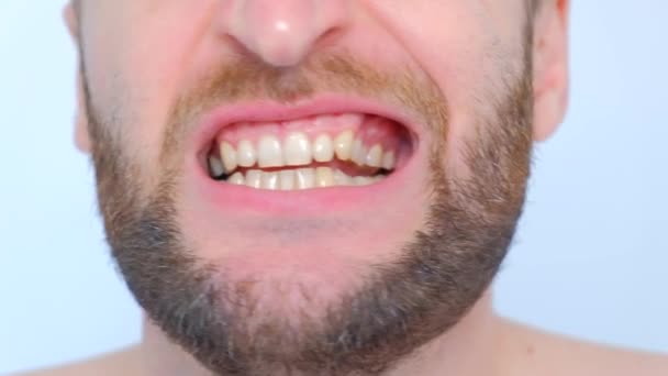 close-up man mond grote lippen en witte tanden plukken een vinger in zijn tanden - Video