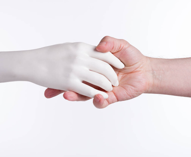 Händedruck lebender männlicher und künstlicher weiblicher Hände auf isoliertem Hintergrund. - Foto, Bild
