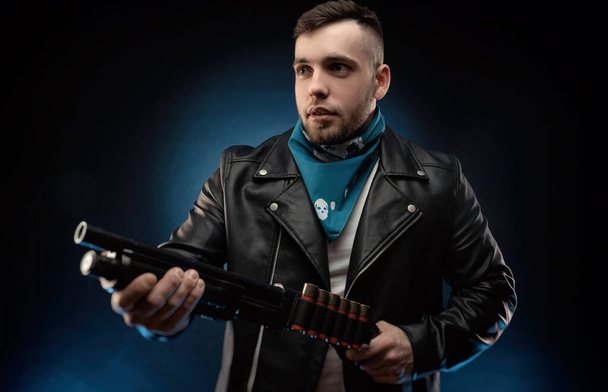 guy in a leather jacket with a shotgun - Zdjęcie, obraz