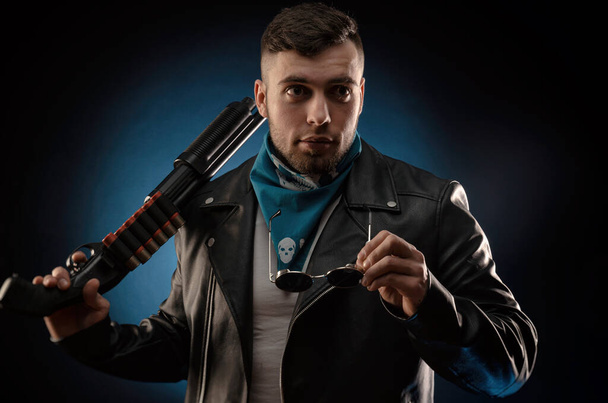 guy in a leather jacket with a shotgun - Zdjęcie, obraz