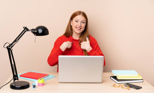 Junge Studentin am Arbeitsplatz mit Laptop und überraschtem Gesichtsausdruck - Foto, Bild