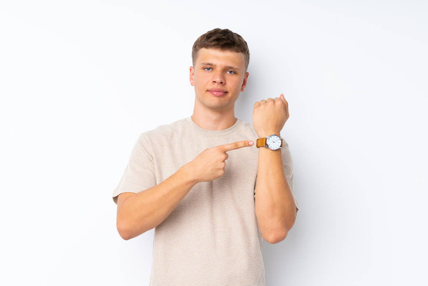 Молодий красивий чоловік над ізольованим білим тлом, що показує ручний годинник
 - Фото, зображення