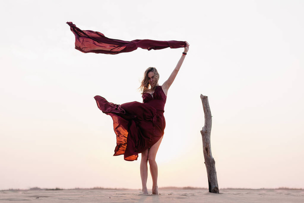 wind inflates a girl's dress in the desert - 写真・画像