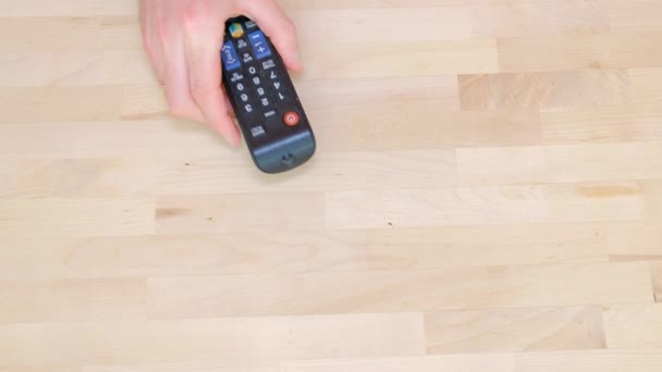 a male hand with a TV remote control switches channels - Footage, Video