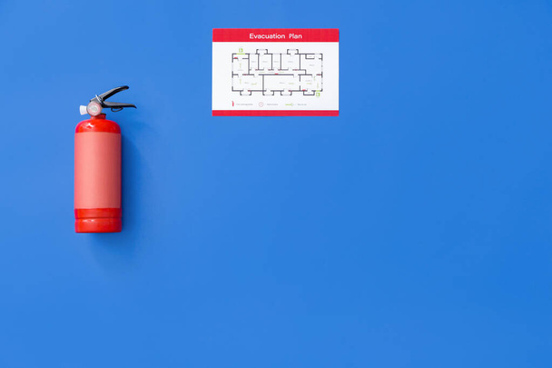 Extintor de incêndio e plano de evacuação em fundo colorido
 - Foto, Imagem