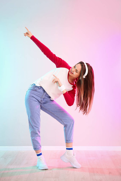Young female hip-hop dancer against color wall - Photo, Image