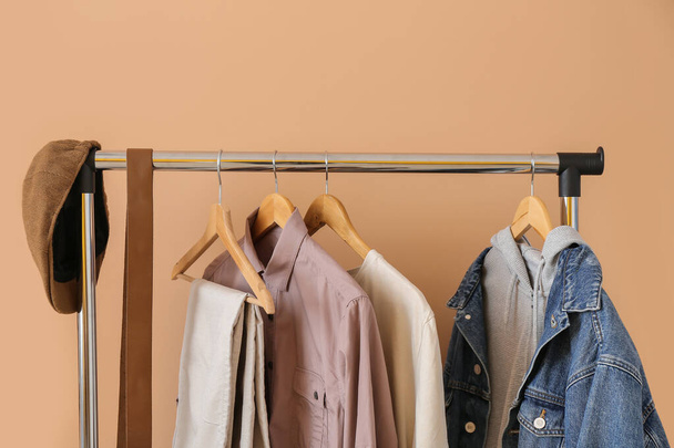 Rack with clothes near color wall - 写真・画像