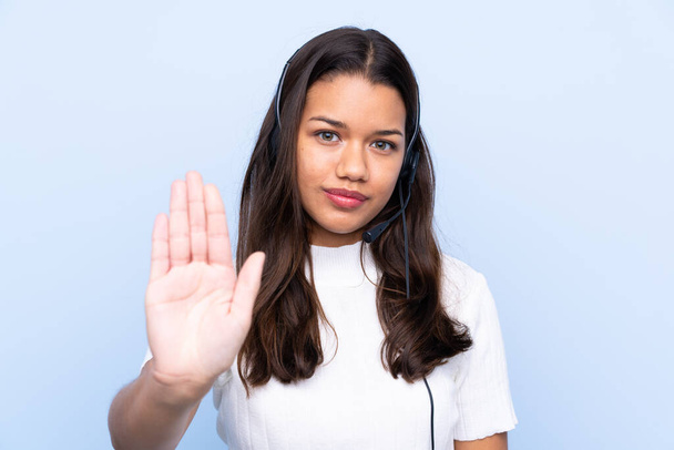 jovem telemarketer colombiano mulher sobre isolado fundo azul fazendo parar gesto com a mão
 - Foto, Imagem