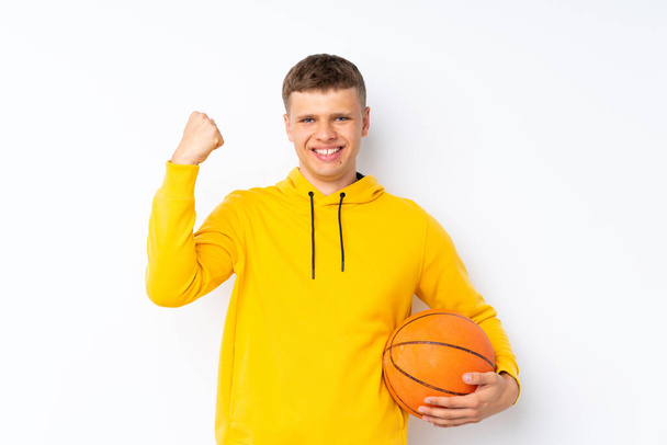 Νεαρός όμορφος άντρας πάνω από απομονωμένο λευκό φόντο με μπάλα μπάσκετ - Φωτογραφία, εικόνα