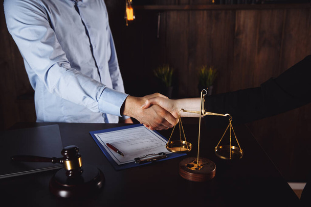 Бизнесмен пожимает руку, чтобы заключить сделку со своими партнёрами-юристами или адвокатами, обсуждающими договор
 - Фото, изображение