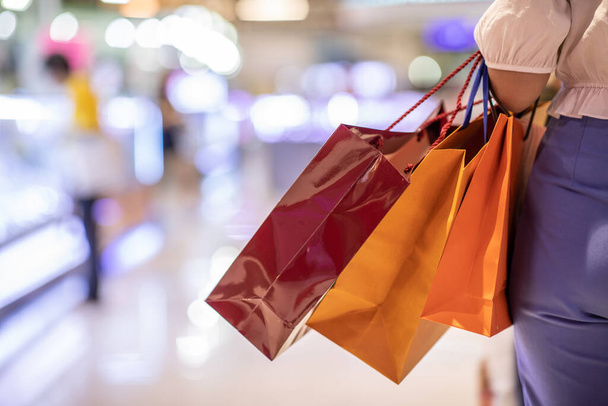 Close up Woman holding shopping bags in her hand walking in shopping mall,Shopping Concept - Photo, image