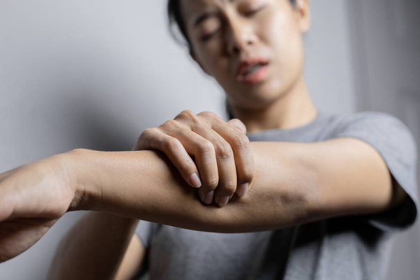 Woman suffering from pain in arm. Concept pain in arm. Young woman with pain in arm. - Photo, Image