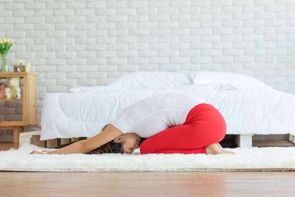 Attractive Asian woman practice yoga Child's pose to meditation in bedroom after wake up in the morning Feeling so comfortable and relax,Healthcare Concept - Photo, image