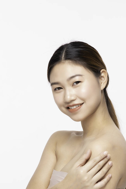 Side View Of Beautiful Young Asian Woman Looking While Touching Shoulder feeling so happy and cheerful with healthy Clean and Fresh skin,isolated on white background,Beauty Cosmetology Concept - Foto, imagen