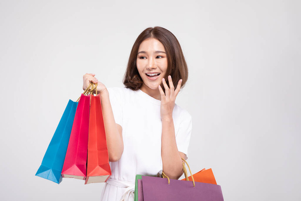 Shopping Asian woman with short hairs smile and Holding Shopping bags, Cheerful and happiness emotional, Enjoy Shopping in black friday sale, Isolated on gray background, Shopping Concept - 写真・画像