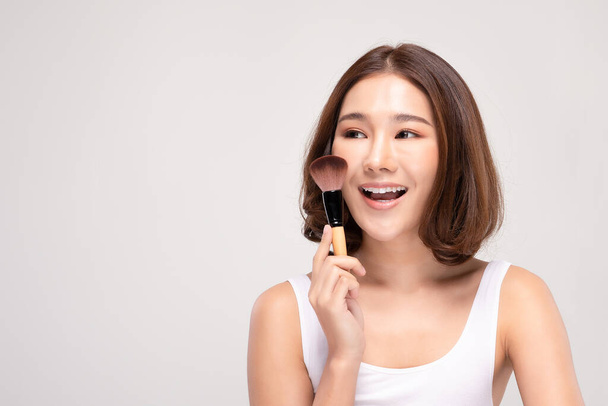 Linda mulher jovem asiática sorrir e segurando maquiagem escova com saudável Pele limpa e fresca sentindo tão felicidade e alegre, Isolado no fundo branco, Beauty Cosmetics Concept - Foto, Imagem