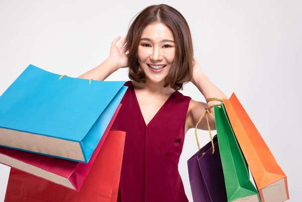 Shopping Asian woman with short hairs smile wearing red dress Holding Shopping bags,Cheerful and Happiness enjoy shopping in black friday sale,Isolated on gray background - Photo, image