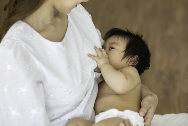 Mãe segurando seu filho recém-nascido e amamentando de mama mãe natural para fazer sistema de imunidade em crianças para o bebê saudável, conceito de bebê saudável, foco seletivo
 - Foto, Imagem