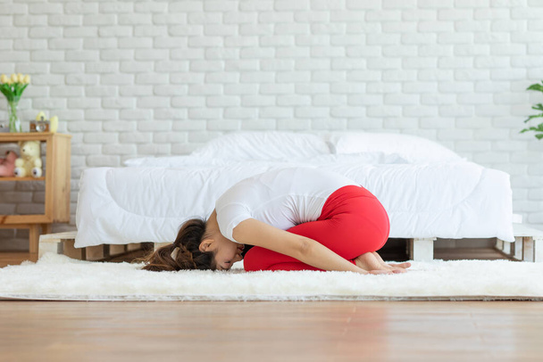 Attrayant asiatique femme pratique yoga pose de l'enfant à la méditation dans la chambre à coucher après le réveil le matin Se sentir si à l'aise et se détendre, Healthcare Concept
 - Photo, image