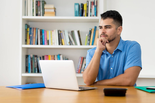 Thinking hispanic hipster man stay at home and work with concentration at computer at home - Photo, Image