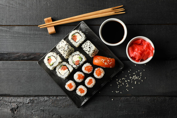 Tray with delicious sushi rolls on wooden background, top view. Japanese food - Photo, Image
