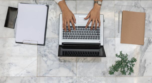 Vista superior de la mano de la mujer de negocios que trabaja con el ordenador portátil en la mesa de trabajo con el portátil y el teléfono inteligente, Business Working Concept
 - Foto, imagen