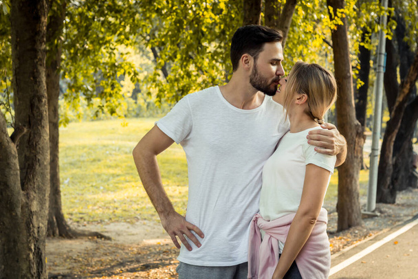 A tinédzser párok szeretetet mutatnak egymásnak a parkban. A párok a parkban tornáznak reggel. A fiatal pár koncepciója a parkban. - Fotó, kép