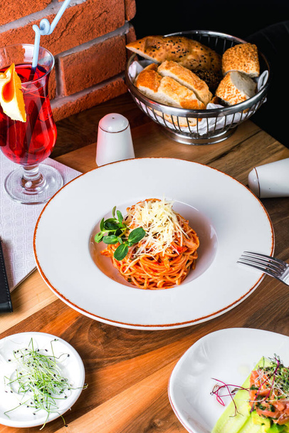 pasta with grated cheese and basil served with cocktail and bread - Foto, imagen