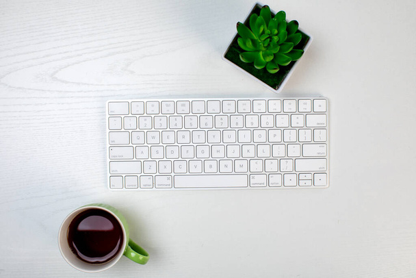 een kopje koffie en draadloos toetsenbord - Foto, afbeelding