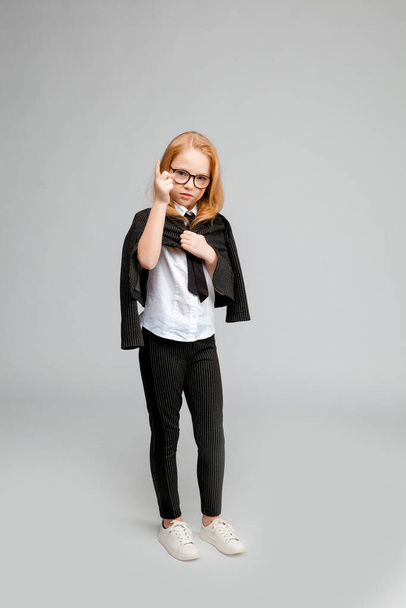 red-haired girl in a business suit looks sternly and points a finger - Fotoğraf, Görsel
