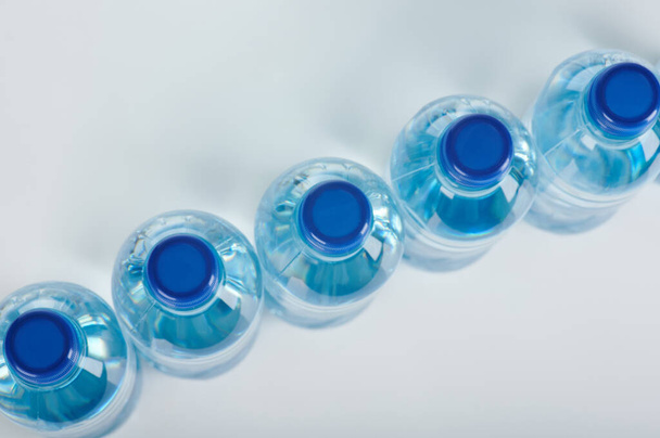 Blauwe plastic flessen boven bovenaanzicht op diagonaal  - Foto, afbeelding