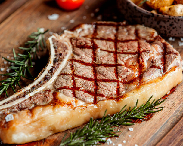 a large piece of steak with tarragon leaves - Zdjęcie, obraz