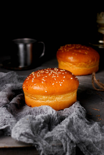 freshly baked bun with sesame seeds on the table - Fotó, kép