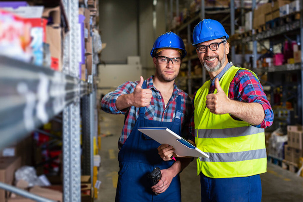 Workers in warehouse with thumb up. - Photo, Image