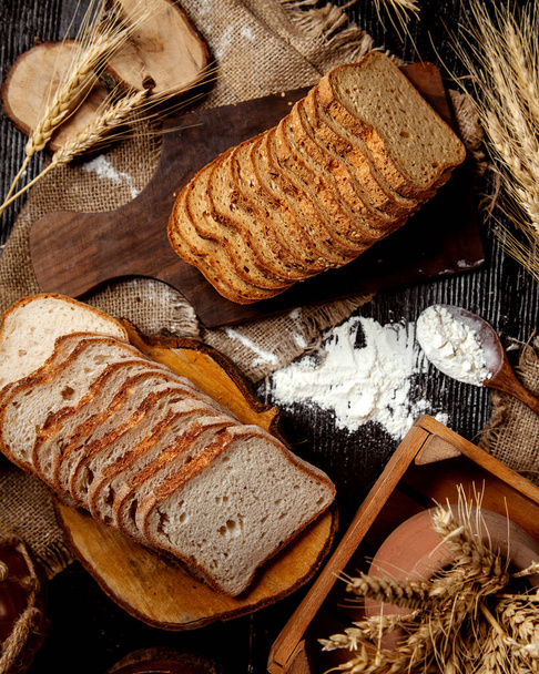 sliced slices of wheat bread on a wooden board - Foto, afbeelding
