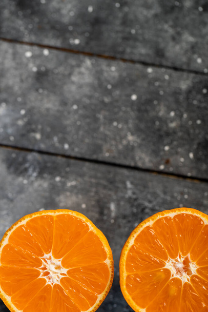 sliced in half an orange on a wooden table - Φωτογραφία, εικόνα
