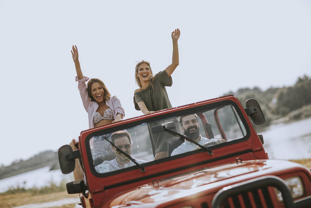 Grupa szczęśliwych młodych ludzi korzystających z podróży samochodem - Zdjęcie, obraz
