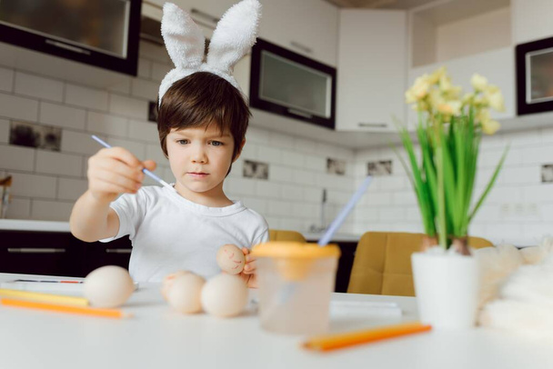 Cute little boy painting Easter eggs. Happy child with Easter eggs - Фото, зображення