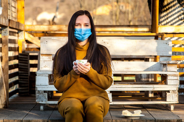 dívka v masce drží hrnek čaje. karanténa. - Fotografie, Obrázek