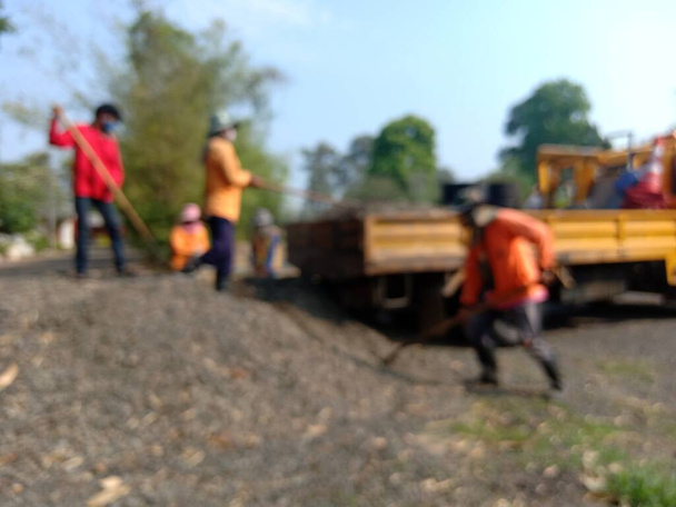 Görüntü bulanık, kamyonda taş taşıyan işçiler yolu onarmak için gidiyorlar. - Fotoğraf, Görsel