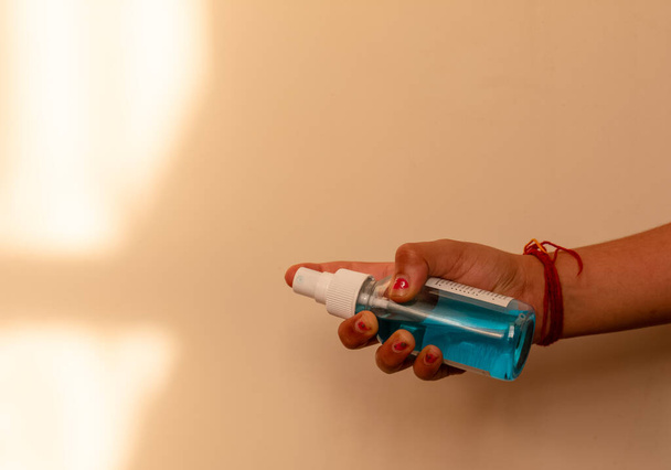 Gewassen beeld van de man met de hand ontsmettingsmiddel in fles - Foto, afbeelding