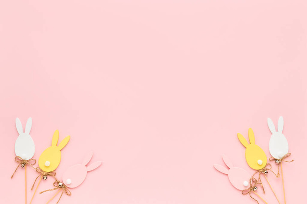 Decoración de Pascua. Huevos de Pascua de madera de colores sobre fondo rosa. Tarjeta de felicitación. Vista superior, espacio de copia
 - Foto, Imagen