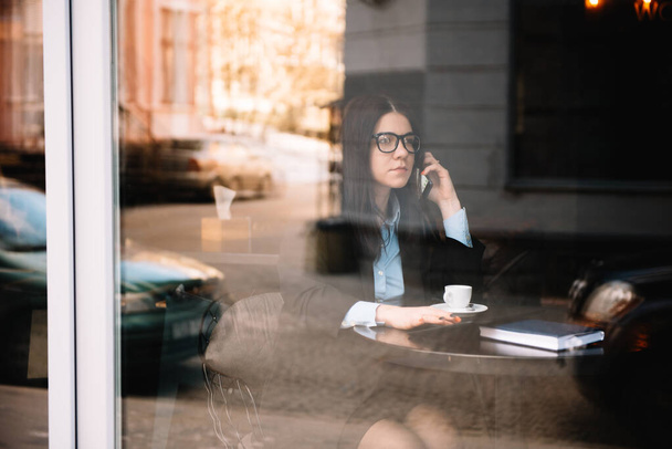 Young businesswoman talking on the phone in coffee shop - Foto, Bild
