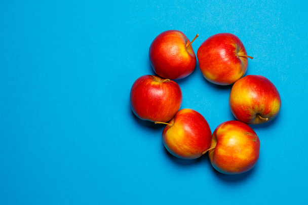 punainen-keltainen mehukas omenat sinisellä pohjalla. Terveellinen ravitsemus ja vitamiinit
 - Valokuva, kuva