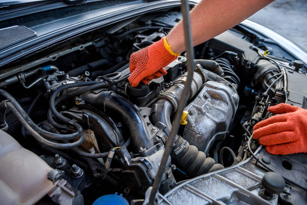 Hands in protective gloves with car engine close up. Car repair concept - Φωτογραφία, εικόνα