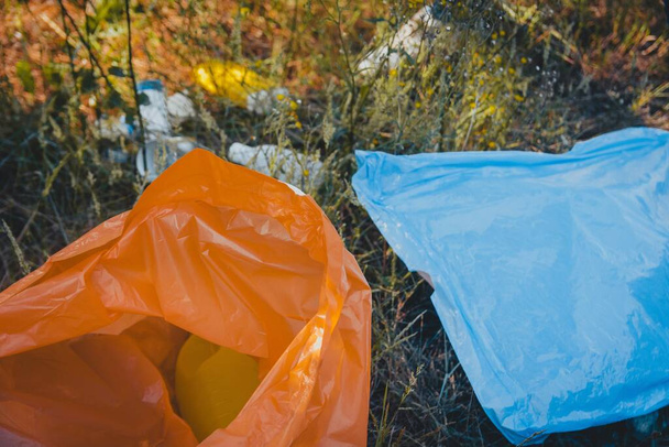 A high angle shot of plastic garbage bags on the ground - plastic pollution concept - 写真・画像