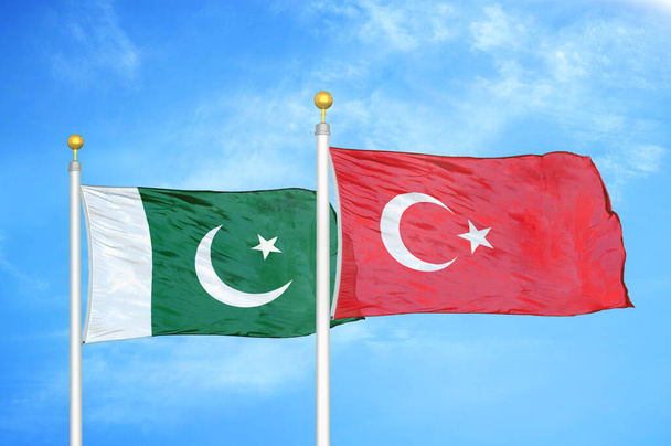 Paquistão e Turquia duas bandeiras em postes de bandeira e azul céu nublado fundo
 - Foto, Imagem
