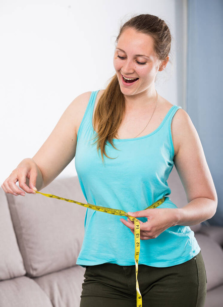 Νεαρή γυναίκα επιτυγχάνει την επιτυχία με την απώλεια βάρους στο σπίτι - Φωτογραφία, εικόνα