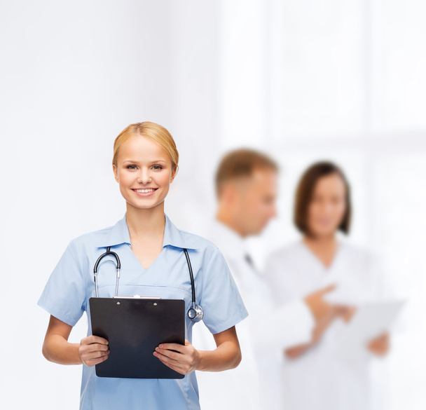 Smiling female doctor or nurse with clipboard - Zdjęcie, obraz